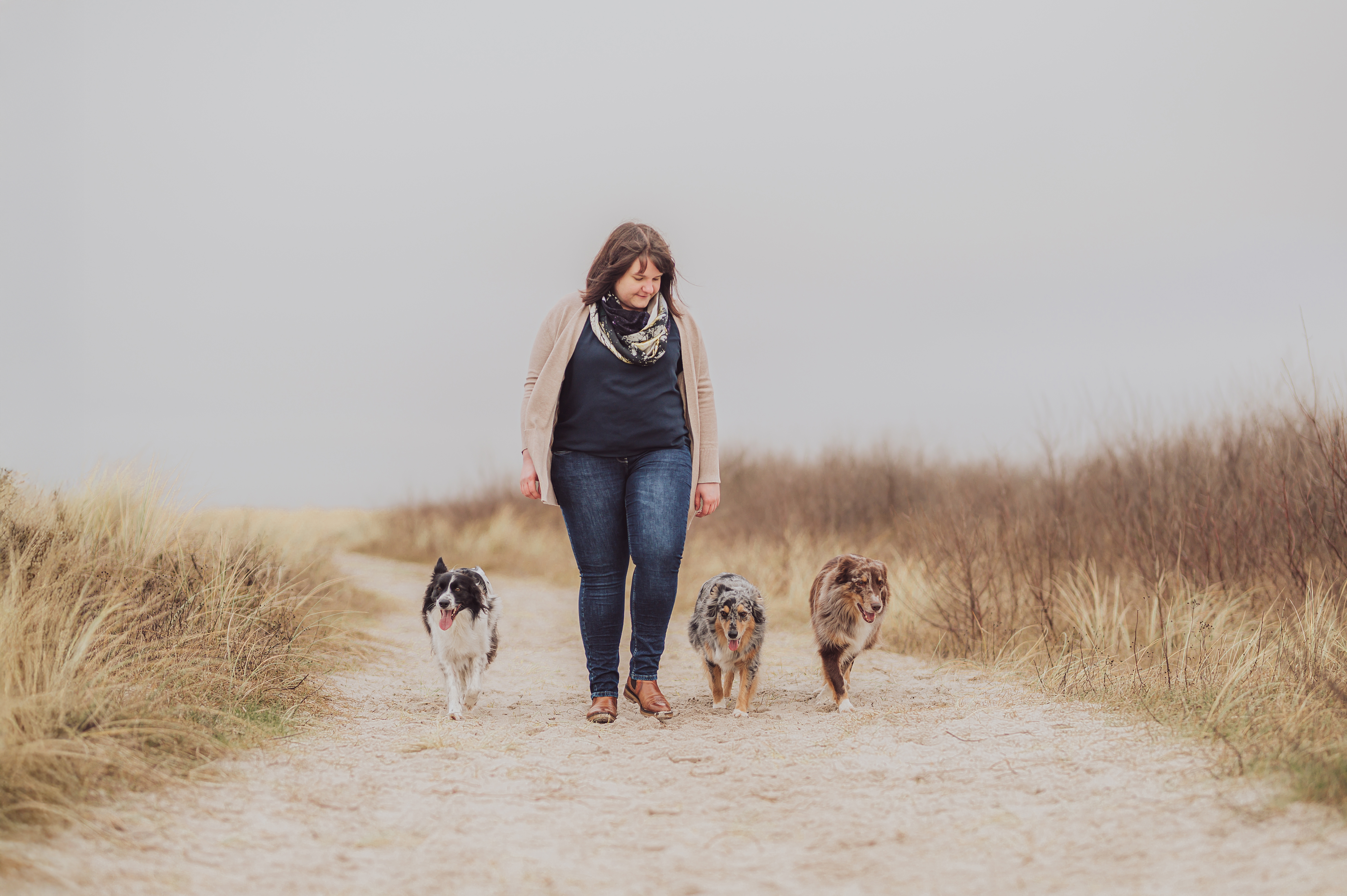Katharina Tobsch geht mit ihren drei Hunden einen Sandweg entlang
